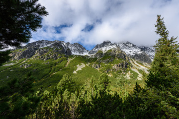 slovakian carpathian mountains in autumn. green hills with tops covered in first snow and white clouds above