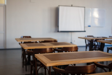 Inside the old classroom with blackboard, desks and chairs.