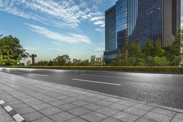 Empty urban road and modern buildings under blue sky