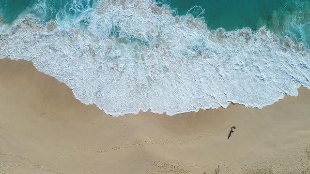 Aerial view of ocean waves crashing on beach by 4K drone footage