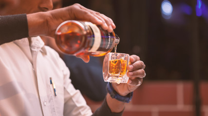 A bartender making whiskey peg in an Indian wedding.