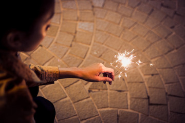 lady sitting play firesparkler blink in her hand at night toning
