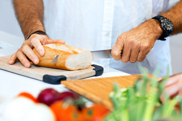 Male hands cutting bread