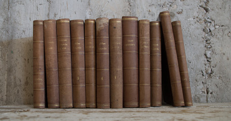 libri antichi vintage appoggiati a muro grezzo