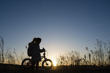 自転車で遊ぶ子供のシルエット