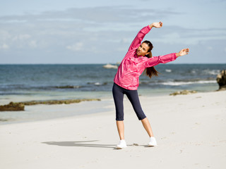 Young woman at the beach doing exercises