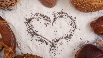 Different types of bread on wooden table dusted with flour