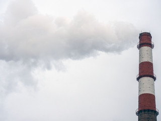 The pipe of a coal power plant with white smoke as a global warming concept.