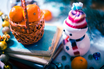 Mandarins in a small basket on a pile of books.