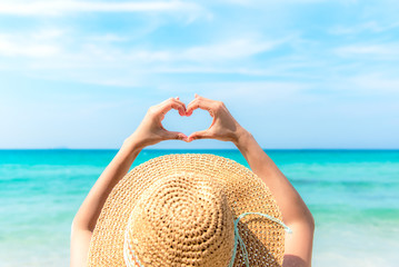 Woman making heart shape on the beach.  Valentine Concept.