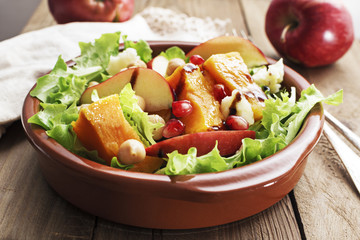 Salad with apple ,pumpkin and melogran on rustik background.