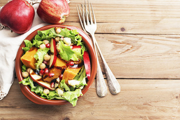 Salad with apple ,pumpkin and melogran on rustik background.