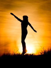 Silhouette of a girl jumping at sunset