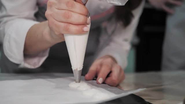 Process of making macaron (macaroon), french dessert, squeezing the dough form cooking bag. Food industry, mass or volume production.