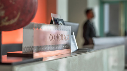 Concierge service desk counter with hotel staff team working in front of reception hall for tourist business customer