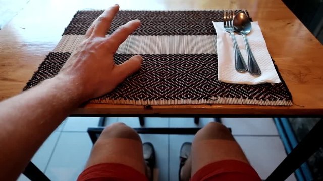 Caucasian man sitting in cafe and waiting for lunch or dinner. He nervously knocks his fingers on the table.