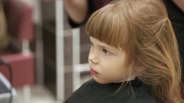 Small girl at hairdressing saloon
