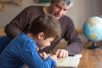 Caucasian father and son doing mathematics homework