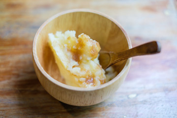 Mashed potatoes in a wooden plate with the wooden spoon on the table / Shallow depth of field - Selective focus