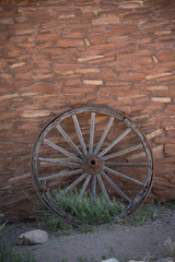 Fototapeta na wymiar Wooden Wheel on Brick Wall Vertical