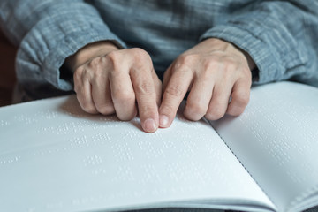 World braille day concept with blind person reading braille text touching the relief on book with finger