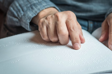 World braille day concept with blind person reading braille text touching the relief on book with...