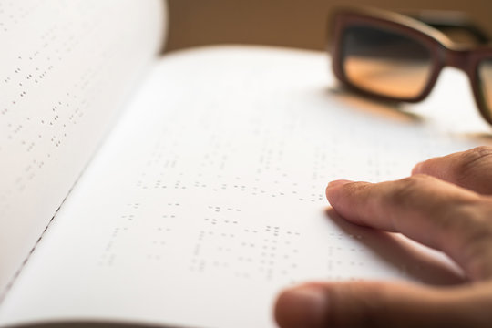 World braille day concept with blind person reading braille text touching the relief on book with finger
