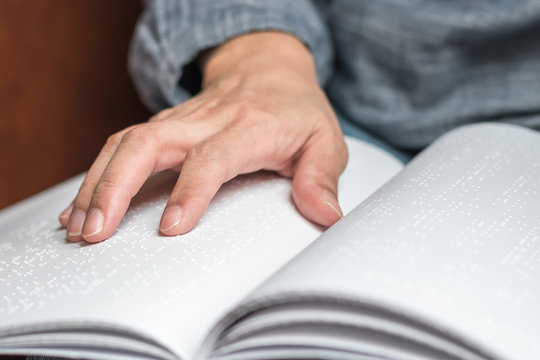 World braille day concept with blind person reading braille text touching the relief on book with finger