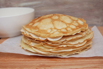 Delicious pancakes traditional for Russian pancake week on wooden board. close up.