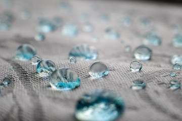 Blue drops on water repel textile fabric fibers. Close-up macro