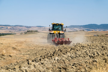 Obraz premium Peasant on the tractor while preparing the field for sowing
