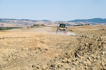 Peasant on the tractor while preparing the field for sowing
