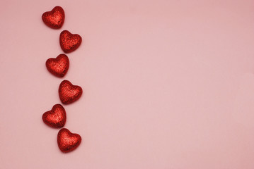Valentines Day background, red sparkle hearts, top view against pink background with copy space