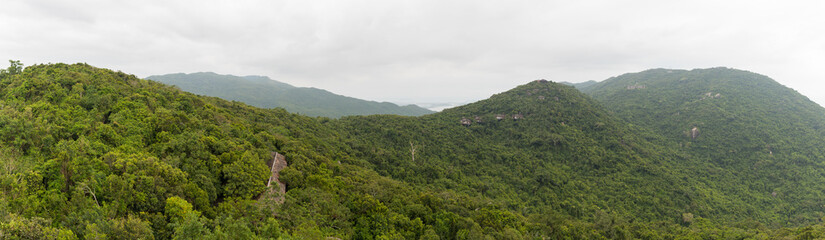Fototapeta na wymiar Panoramic view of the tropical mountains covered with dense vegetation from the observation deck in the Yalong Bay Tropic Paradise Forest Park