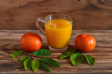 The mandarins and tangerine juice on a wooden background