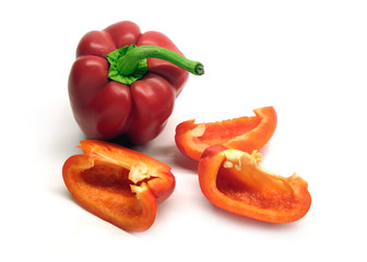 Still life with two whole and cutted red ripe bell peppers isolated on white background close up