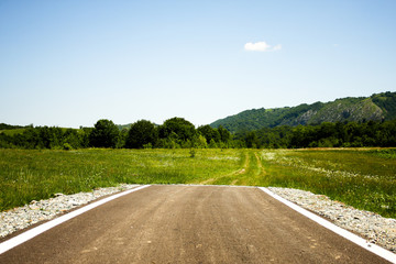 A paved road suddenly ending in the middle of nowhere - obrazy, fototapety, plakaty