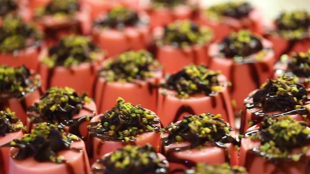 Closeup view of many small cakes served on table for cocktail party or on shelves at store.