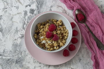 Breakfast muesli with nuts and dried fruits and fresh raspberries