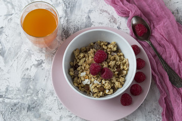 Breakfast muesli with nuts, dried fruits, fresh raspberries and orange juice, yogurt on the table mindalминдальfonfonefonovyi riezhimkontiekstobrazovaniiepodghotovkapodopliokapriedposylkapriedystoriia