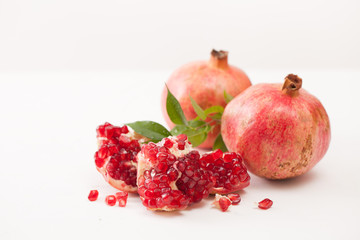 Pomegranate fruits with peeled pomegranate on a white