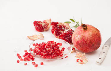 Pomegranate fruits with peeled pomegranate on a white