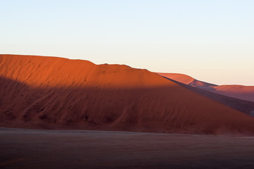 Fototapeta na wymiar Detail view of red sand dunes in Sossusvlei near Sesriem in famous Namib Desert in Namibia, Africa. Sossusvlei is a popular tourist destination, the dunes are amongst the highest in the world.