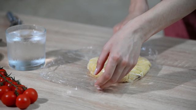 Woman wrapped the dough in plastic