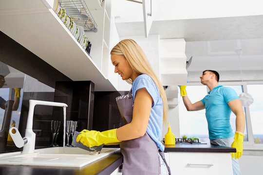 The Couple Is Cleaning In The Kitchen. Cleaning The Room.