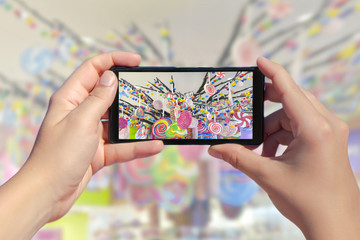 Women's hands take a picture of many candies on a smartphone. Picture of colorful sweets, caramel...