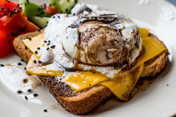 Poached Egg on Toast Bread with Cheddar Cheese, Balsamic Vinegar, Salad and Black Sesame or Cumin Seeds