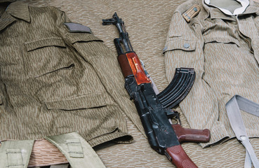 close up on military rifle with camo clothes