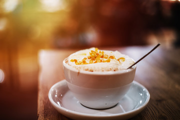 close up on hot  coffee with orange in the bar, lens flare