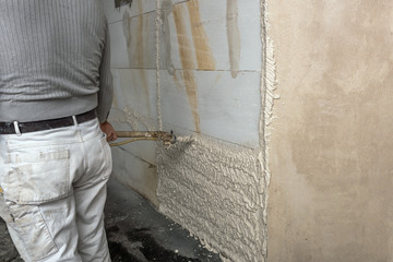 Obraz premium A worker plastered the interior walls with a plaster pump machine on the construction of a private house. Concept; construction site